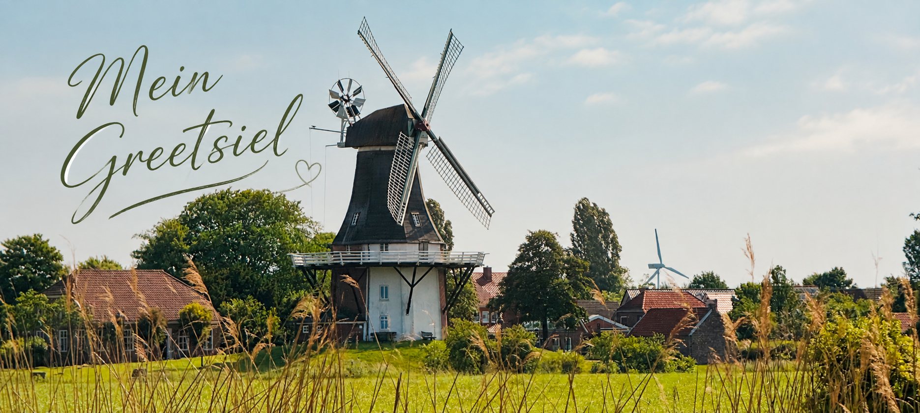Weite Wiese vor einer der Greetsieler Zwillingsmühlen, darüber der Schriftzug Mein Greetsiel